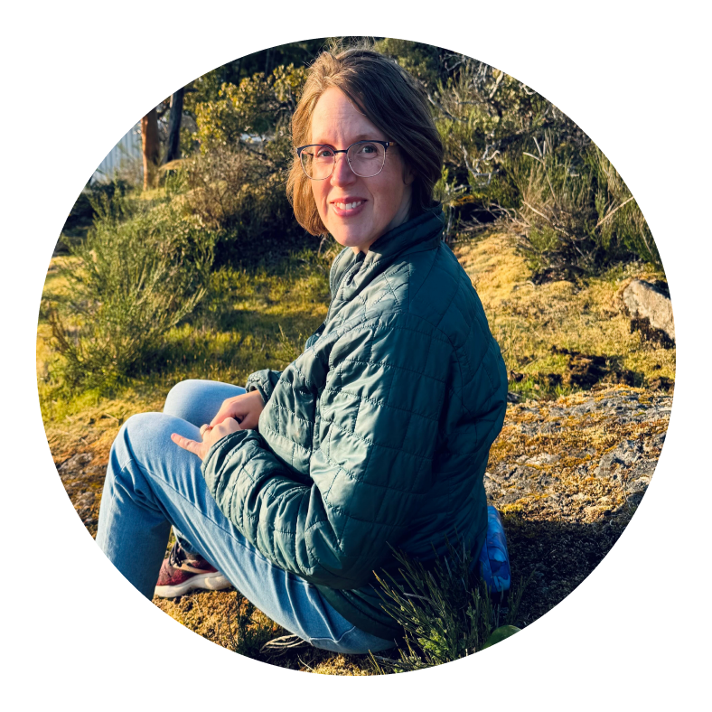 Anne-Lynn sitting on a hillside overlooking a lake